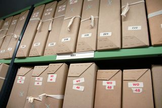 Rows of labelled document boxes on repository shelving at The National Archives in Kew.